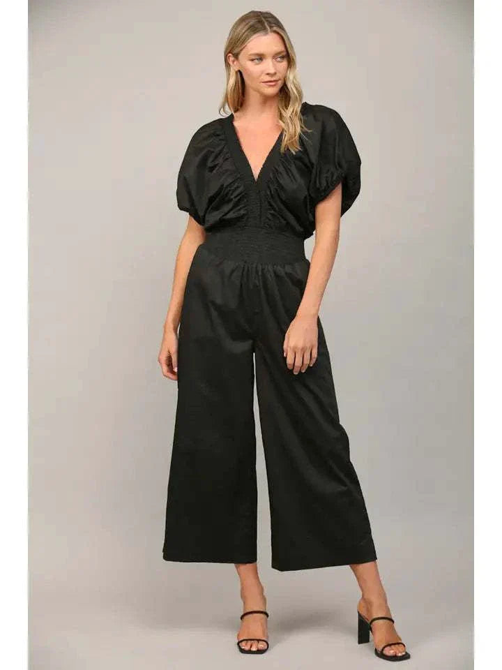 Stylish black open tie back jumpsuit with wide legs and puffy sleeves.