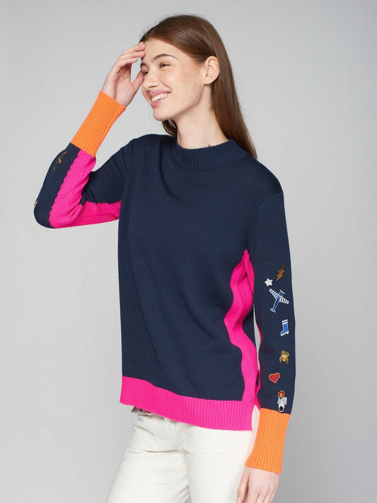 Woman wearing Perkins Turtleneck Embroidered Sweater with colorful trim and sleeve embroidery.